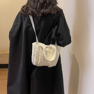 Détail du sac bandoulière en laine d'agneau blanc cassé montrant la texture et l'étiquette
