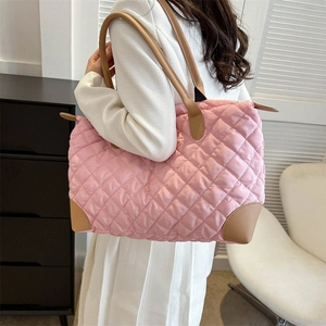 Vue détaillée du sac cabas matelassé rose avec détails en cuir marron sur un mannequin