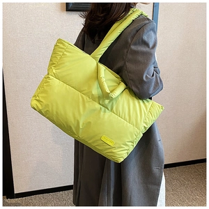 Grand sac cabas matelassé vert citron porté par un mannequin au design rembourré