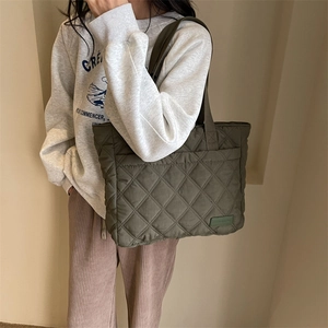 Detailansicht der olivgrünen Stepp-Tote-Bag mit Rautenmuster und gewebtem Stoffetikett