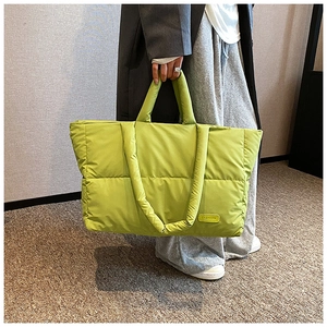 Détail du sac cabas matelassé vert fluo avec rembourrage horizontal et étiquette mode