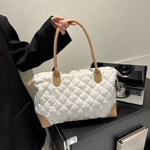 Détail du sac bandoulière matelassé beige avec finitions en cuir marron élégant