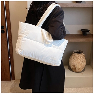 Détail du sac cabas matelassé blanc avec intérieur spacieux et étiquette logo mode