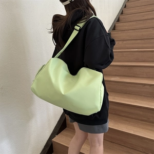 Back view of model wearing a light green Oxford fabric crossbody bag on stairs
