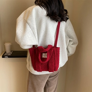 Détail de la texture en peluche rouge et de l'étiquette sur le sac fourre-tout bandoulière