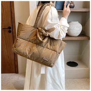 Sac fourre-tout matelassé kaki porté à l'épaule pour un style urbain moderne