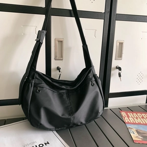Detail of waterproof black nylon crescent bag with adjustable straps and front zip pockets