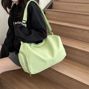 Detail of lime green crossbody bag showing nylon material and adjustable strap on a model