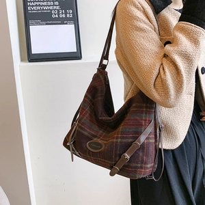 Détail du sac à bandoulière rétro en laine avec bordure en similicuir et logo tendance