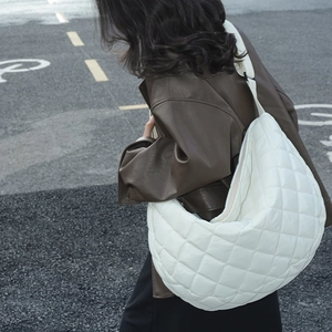 Photo de rue d'un grand sac croissant en nylon matelassé blanc porté par un modèle