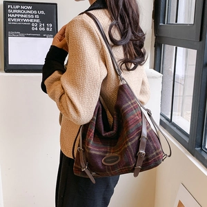 Détail du sac cabas en tweed d'hiver avec motif à carreaux rouge et vert et bandoulière