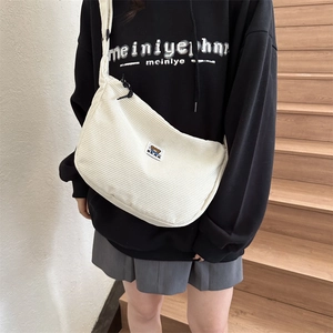Detailed close-up of corduroy crossbody bag featuring a cute bear patch embroidery