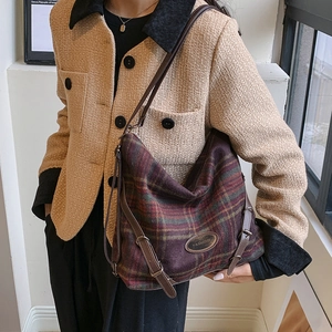 Gros plan du sac bandoulière en laine à carreaux vintage avec étiquette et détails en cuir