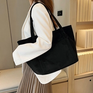 Minimalist black tote bag in soft corduroy texture styled with a white blazer