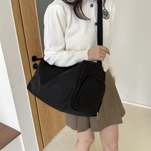 Detail of waterproof nylon crossbody bag featuring cylinder shape and adjustable strap