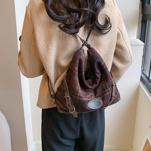 Détail d'un sac à dos vintage en laine à carreaux avec bretelles en cuir marron chic