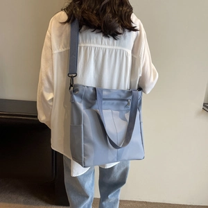 Vue détaillée du sac à bandoulière en nylon bleu clair imperméable avec poche zippée