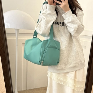 Close-up of mint green waterproof oxford fabric duffel bag with black adjustable strap