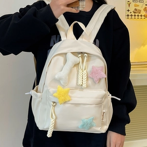 Détail d'un sac à dos en nylon blanc cassé avec d'adorables étoiles en peluche