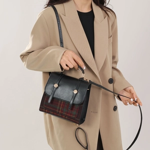 Détail du sac à main vintage à carreaux avec garniture en cuir noir et boutons dorés