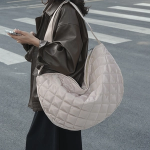Sac à bandoulière en nylon matelassé beige présenté dans un style urbain moderne