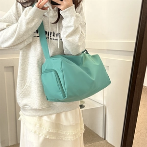 Detail of mint green nylon crossbody bag with wide strap and side zipper pocket