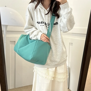 Detail view of mint green quilted puffer crossbody bag with thick shoulder strap