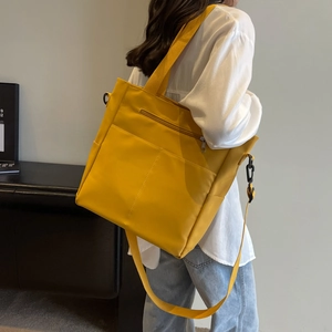 Détail du sac fourre-tout jaune imperméable avec bandoulière noire réglable et robuste