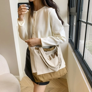 Detail view of canvas tote bag with adjustable shoulder strap and leather contrast trim