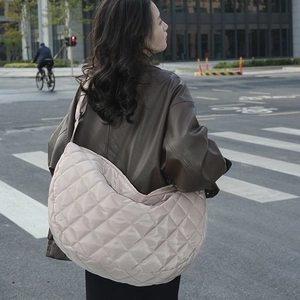 Vue détaillée de l'arrière d'un grand sac hobo matelassé en nylon rose sur l'épaule