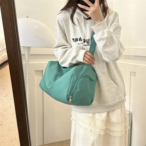 Close-up of mint green Oxford cloth shoulder bag with wide strap and side zipper