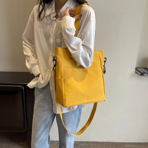 Détail du sac fourre-tout jaune imperméable avec poches latérales et bandoulière