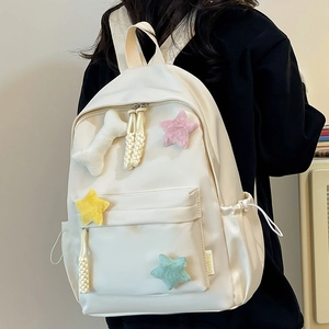Vue détaillée du sac à dos en nylon blanc avec étoiles en peluche et poches latérales