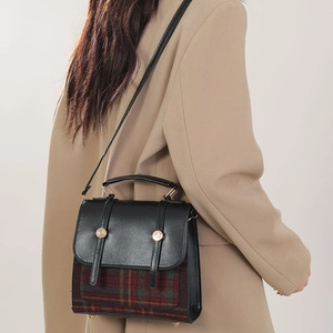 Sac bandoulière rétro britannique avec tissu écossais et cuir noir sur un mannequin