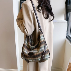 Détail de la texture du tissu en tweed et du logo en cuir tendance sur le sac à bandoulière