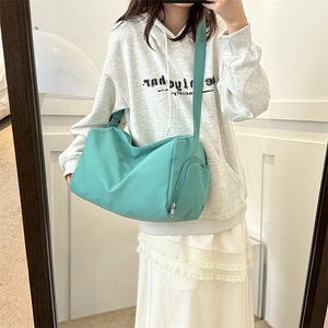 Mint green cylinder oxford crossbody bag shown in mirror selfie with model for size reference