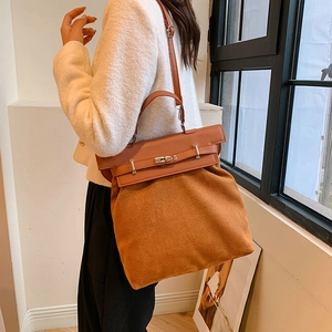 Detail of caramel suede and smooth leather handbag with a silver metal clasp closure