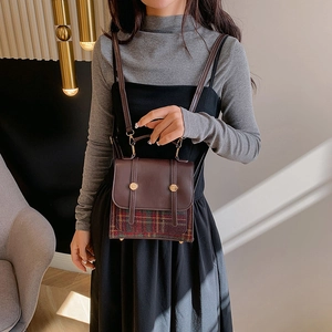 Détail d'un sac bandoulière en cuir PU marron à carreaux avec rabat et bouton doré