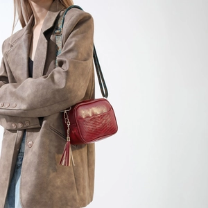 Detailed view of dark red quilted PU leather crossbody bag with ethnic style wide strap