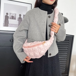 Gros plan du sac nuage rose matelassé avec motifs en losanges et zip doré détaillé