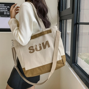Canvas tote bag with 'SUN' print shown from the side to highlight large capacity