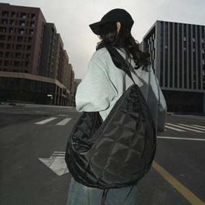 Gros plan sur le grand sac hobo en nylon matelassé noir montrant la texture et l'éclat