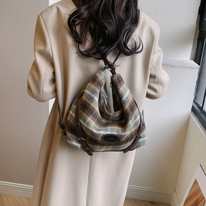 Détail de la texture en laine rayée et du logo en cuir sur ce sac à main tendance