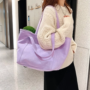 Detail view of a large purple tote bag shown on model for casual commuting style