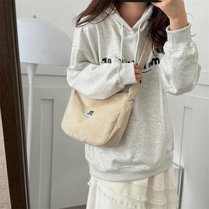 Mirror selfie showing the beige corduroy crossbody bag with cute bear patch detail