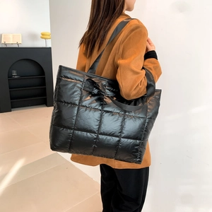 Chic black quilted puffer tote bag with high-gloss finish for winter fashion styling