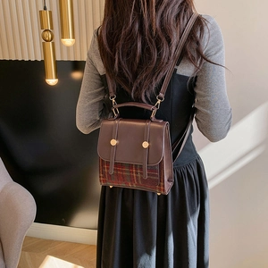 Sac à bandoulière rétro pour femme en cuir marron et motif à carreaux vert porté par modèle
