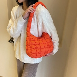Détail d'un sac nuage matelassé orange en nylon avec une texture rembourrée douce