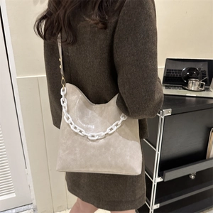 Beige faux leather shoulder bag with decorative resin chain and adjustable strap