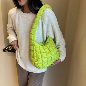 Texture détaillée du sac à main matelassé vert néon porté comme un sac à bandoulière